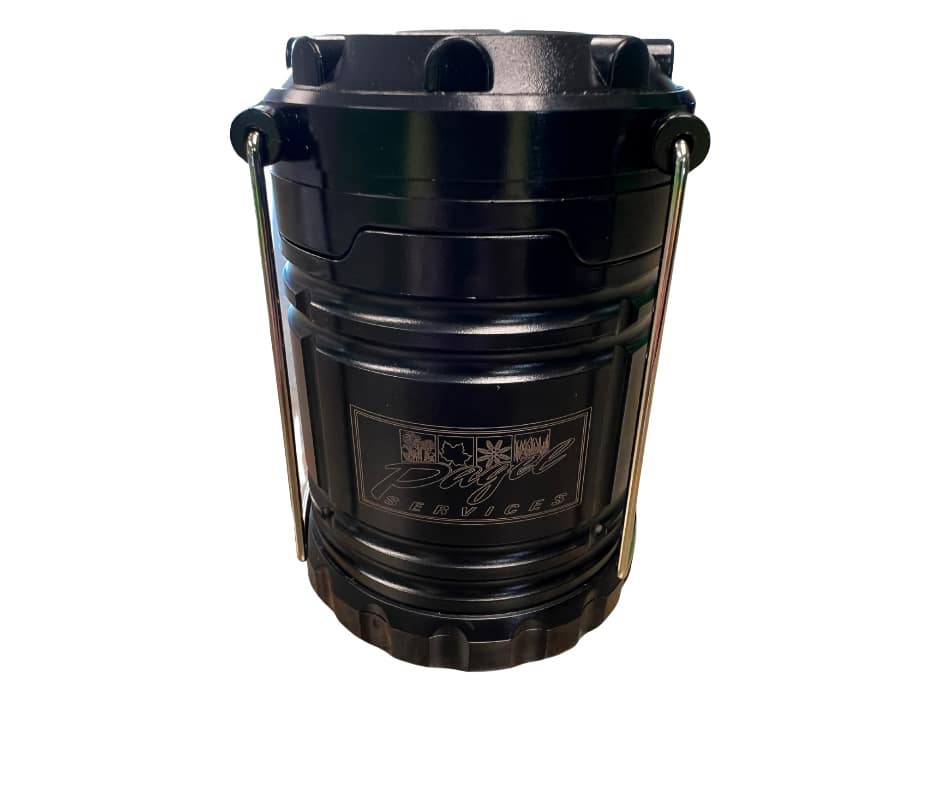 Compact LED camping lantern with telescoping design and metal hanging handles, turned on and glowing bright.||